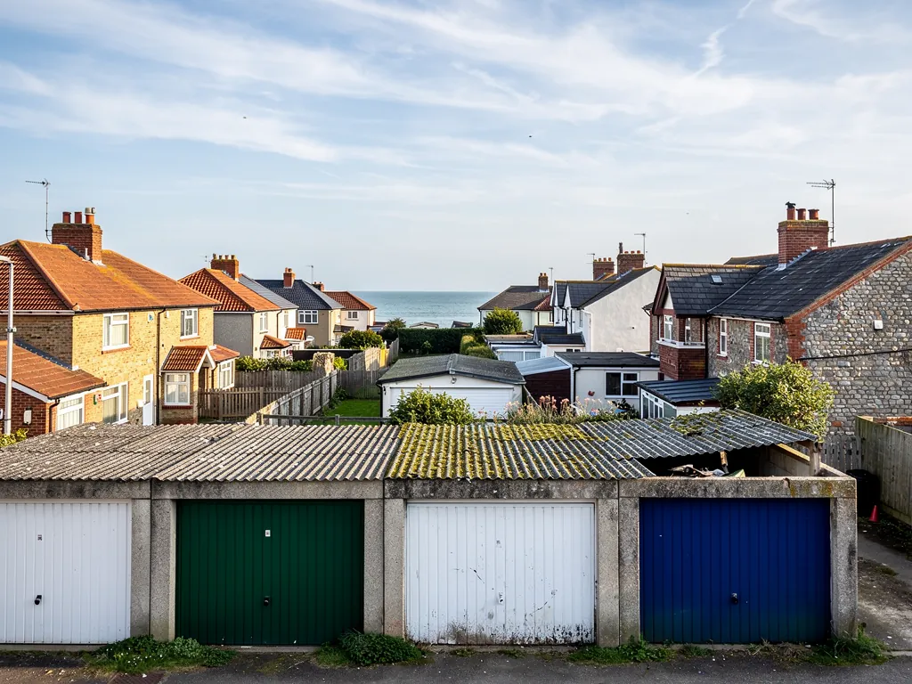 A row of sectional garages with weathered corrugated roof sheets